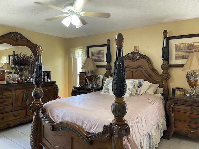 bedroom featuring a textured ceiling, light tile patterned floors, and a ceiling fan