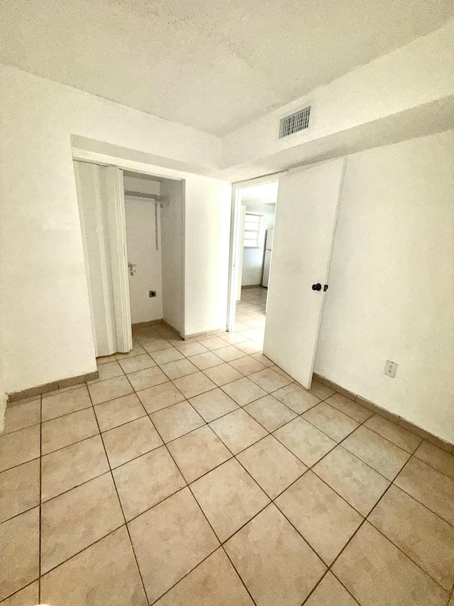 unfurnished room with light tile patterned floors, baseboards, and visible vents