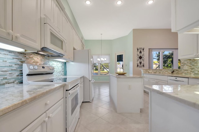 kitchen with decorative light fixtures, light tile patterned floors, white cabinets, a chandelier, and white appliances