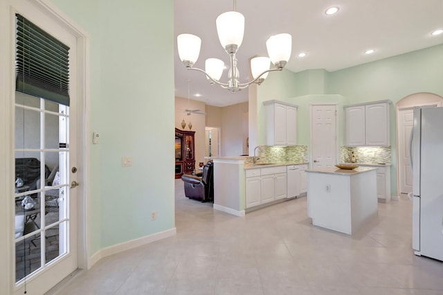 kitchen featuring tasteful backsplash, white appliances, white cabinets, and a sink