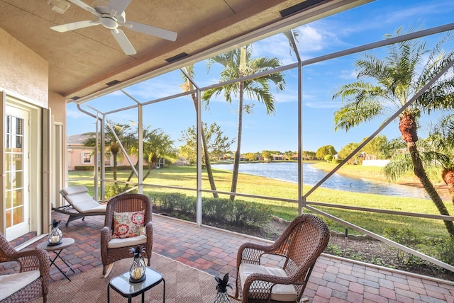 sunroom / solarium featuring a water view and ceiling fan