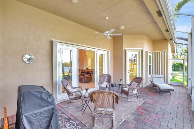 view of patio with a ceiling fan, a lanai, and a grill