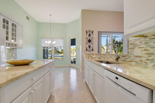 9429 Lantern Bay Cir, West Palm Beach, FL 33411 - kitchen with white dishwasher, a sink, light stone counters, a chandelier, and backsplash
