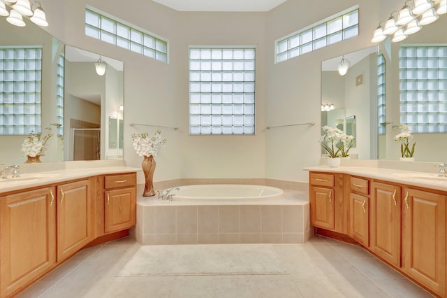 bathroom with a garden tub, tile patterned flooring, a sink, and a shower stall