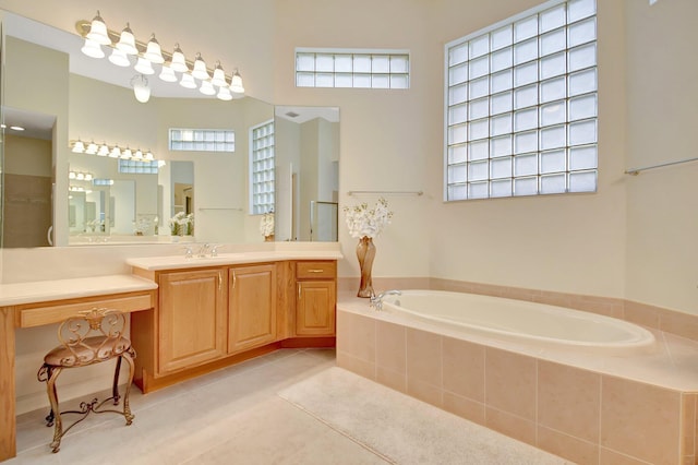 full bathroom featuring tile patterned floors, vanity, and a bath