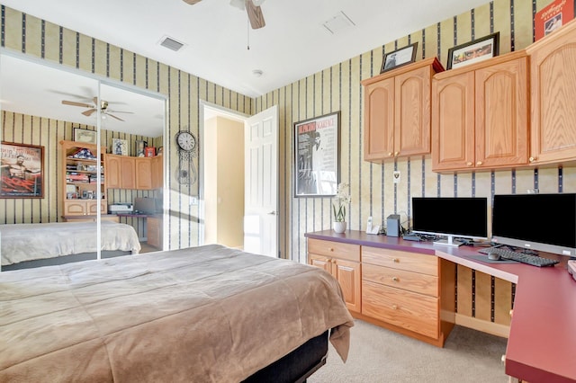 bedroom with light carpet, built in desk, visible vents, and wallpapered walls