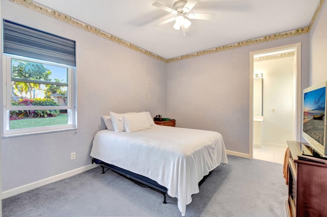 carpeted bedroom with a ceiling fan, baseboards, and ensuite bathroom