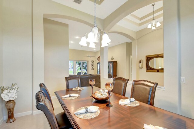 tiled entryway featuring baseboards, arched walkways, and an inviting chandelier