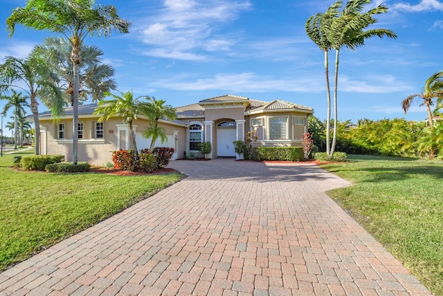 9429 Lantern Bay Cir, West Palm Beach, FL 33411 - mediterranean / spanish house featuring decorative driveway, stucco siding, an attached garage, and a front yard
