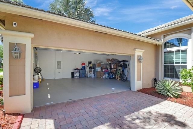 garage featuring decorative driveway and electric panel