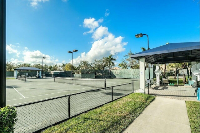 view of tennis court with fence and a gazebo