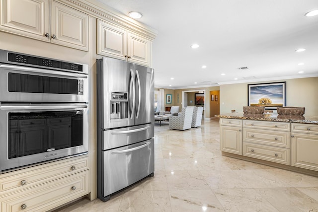 kitchen featuring marble finish floor, cream cabinets, appliances with stainless steel finishes, and crown molding