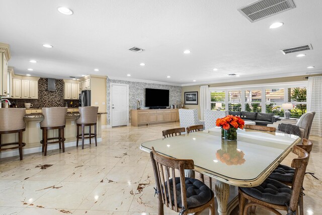 dining space with marble finish floor, visible vents, and crown molding