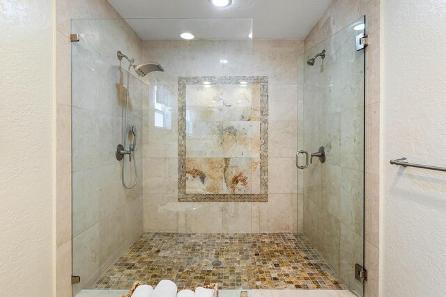 full bath featuring a textured wall and a shower stall