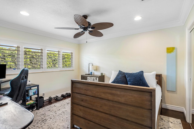 bedroom with baseboards, wood finished floors, a ceiling fan, and crown molding