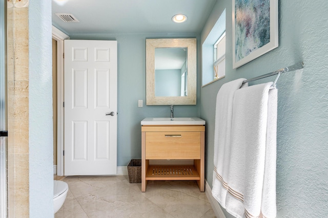 bathroom with marble finish floor, visible vents, toilet, vanity, and baseboards