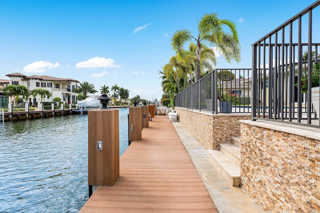 view of dock with a residential view and a water view