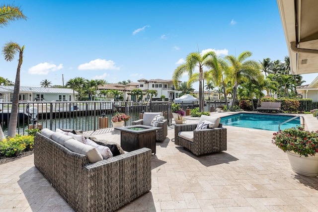 view of swimming pool with fence, a residential view, a fenced in pool, a patio area, and an outdoor living space with a fire pit