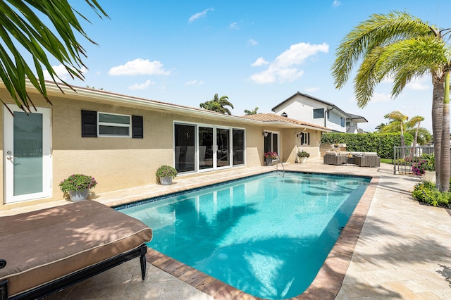 view of swimming pool with a patio, fence, an outdoor living space, and a fenced in pool