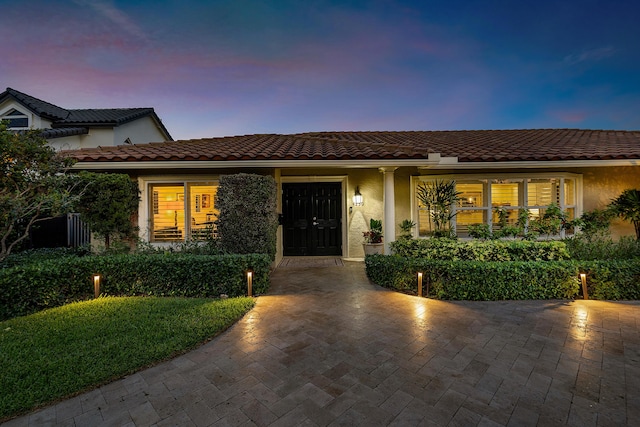 view of front of property with a tile roof and stucco siding