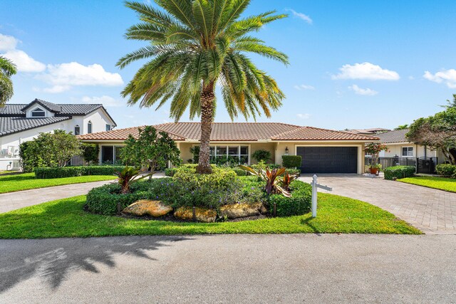 view of front of property with driveway, an attached garage, fence, and stucco siding