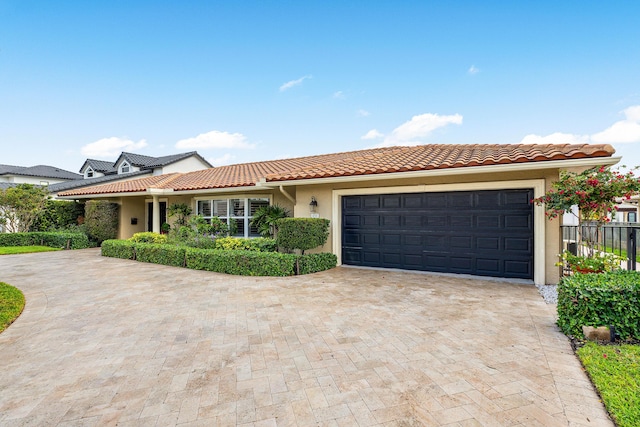 view of front of home with driveway, an attached garage, a tile roof, and stucco siding