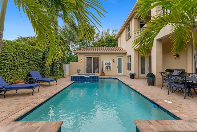 view of pool featuring a patio and a pool with connected hot tub