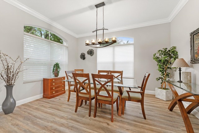 dining room featuring baseboards, plenty of natural light, crown molding, and light wood finished floors