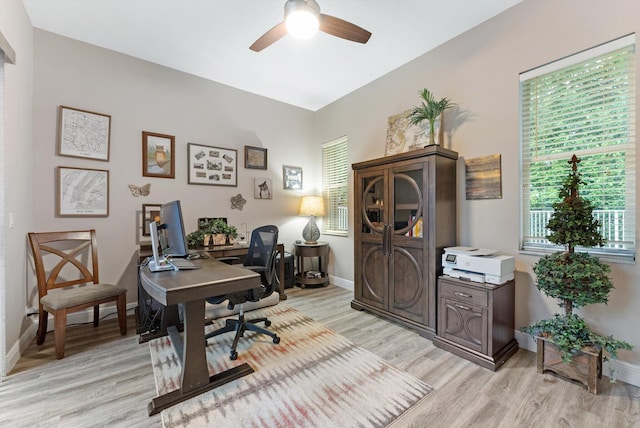office area with light wood-style flooring, baseboards, and ceiling fan