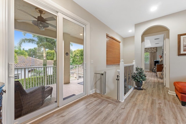 interior space featuring recessed lighting, baseboards, arched walkways, and wood finished floors