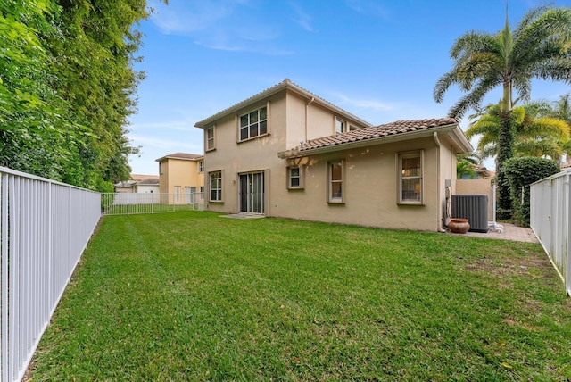 back of house with stucco siding, a lawn, a fenced backyard, and a tile roof