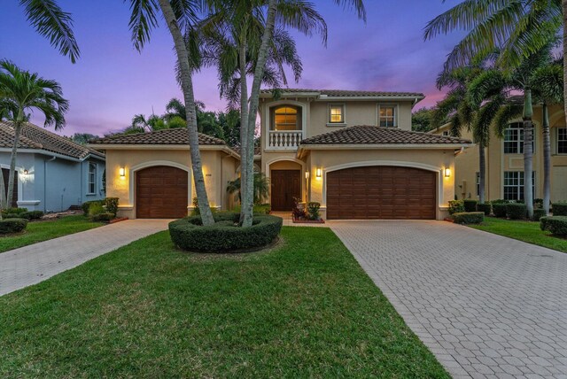 mediterranean / spanish-style house with decorative driveway, an attached garage, and stucco siding