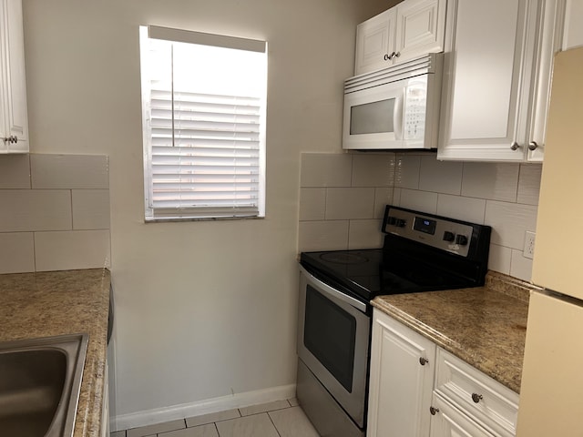 kitchen with white appliances, white cabinets, and a sink