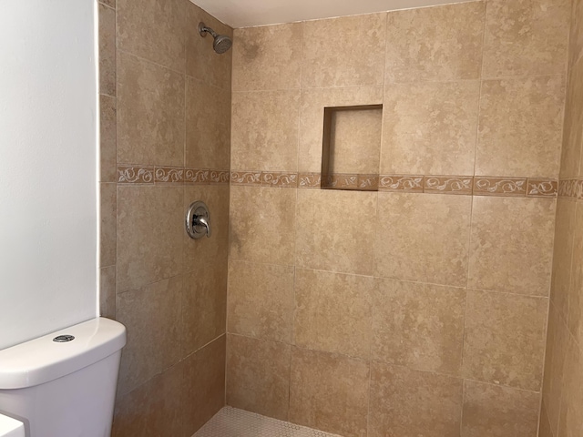 full bath with tiled shower and toilet