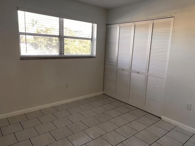 unfurnished bedroom featuring a closet and baseboards