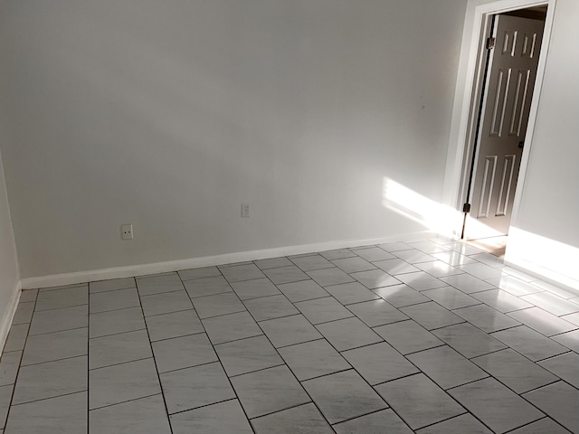 spare room featuring baseboards and tile patterned floors