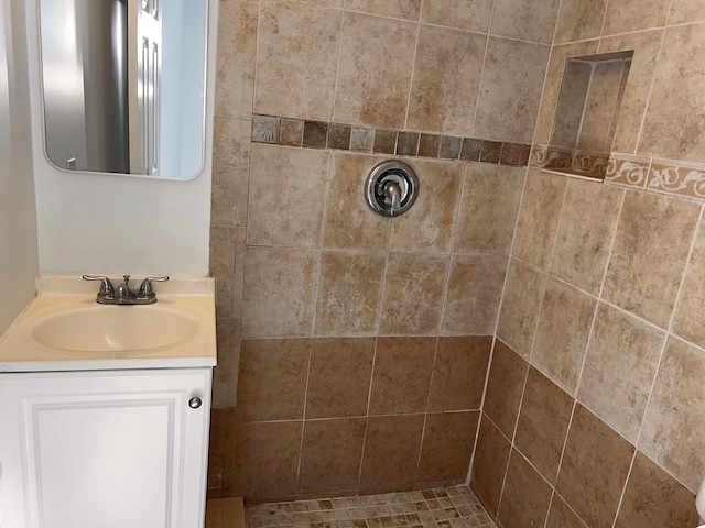 full bathroom with tiled shower and vanity