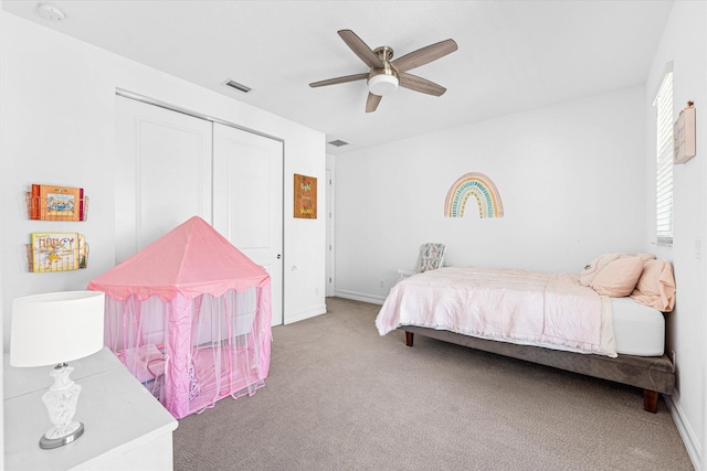 carpeted bedroom featuring ceiling fan, a closet, and visible vents