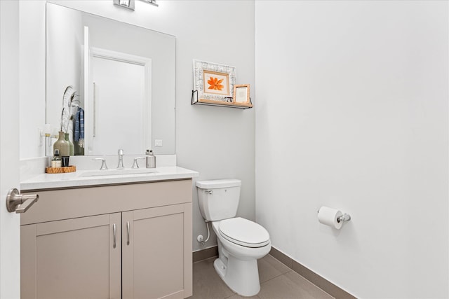 half bath featuring baseboards, vanity, toilet, and tile patterned floors