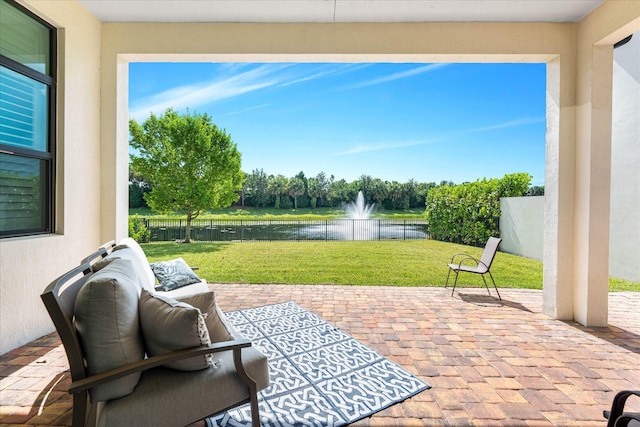 view of patio / terrace with a water view and fence