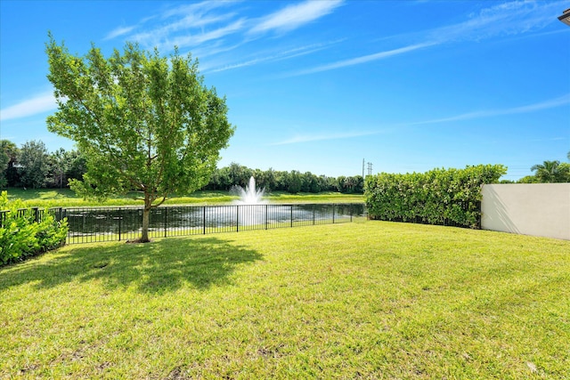 view of yard with a water view and fence