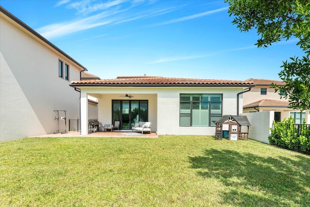 back of property featuring a lawn, a ceiling fan, a patio, fence, and stucco siding