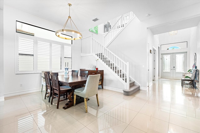 dining space featuring visible vents, baseboards, stairway, an inviting chandelier, and french doors