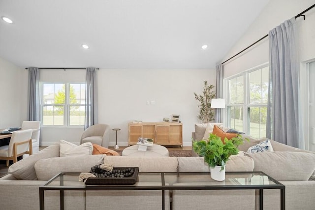 living area featuring recessed lighting, baseboards, and lofted ceiling