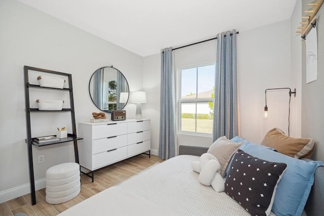 bedroom with light wood-type flooring and baseboards