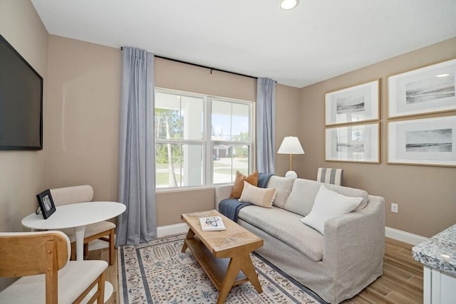 living room with baseboards and light wood-type flooring