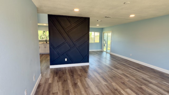 unfurnished room featuring dark wood-style flooring, recessed lighting, visible vents, and baseboards