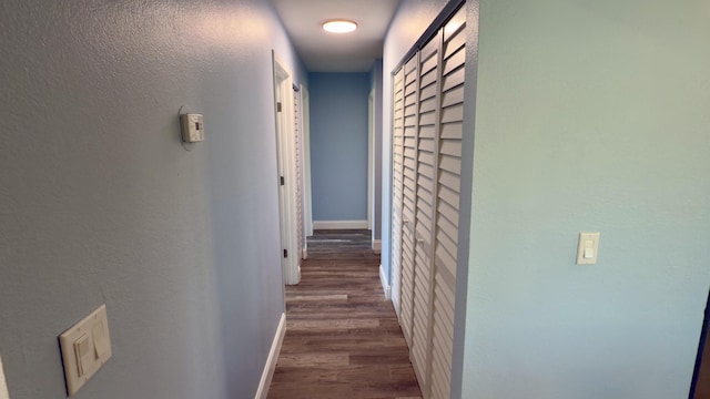 hallway with wood finished floors and baseboards