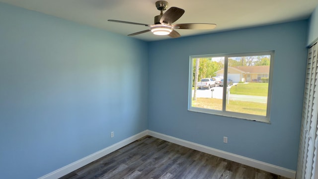 spare room with dark wood-style floors, ceiling fan, and baseboards