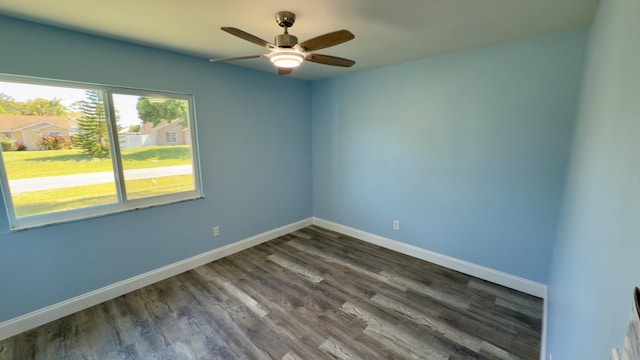 unfurnished room with dark wood-style floors, ceiling fan, and baseboards